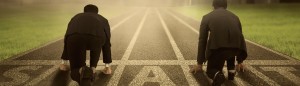 A person in business attire standing at the start line on a racetrack.