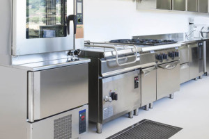 Commercial kitchen with stainless steel appliances and cooking equipment.