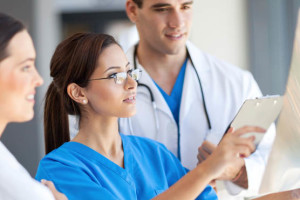 Two healthcare professionals reviewing information on a tablet.