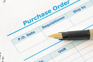 A pen resting on a blank purchase order form.